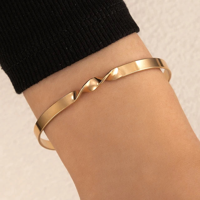 Brenda | Minimalistische dames armband – elegante, subtiele kruisvorm met goudkleurige afwerking